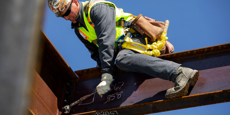 construction man wrenching from steel beams with Carolina pitstop